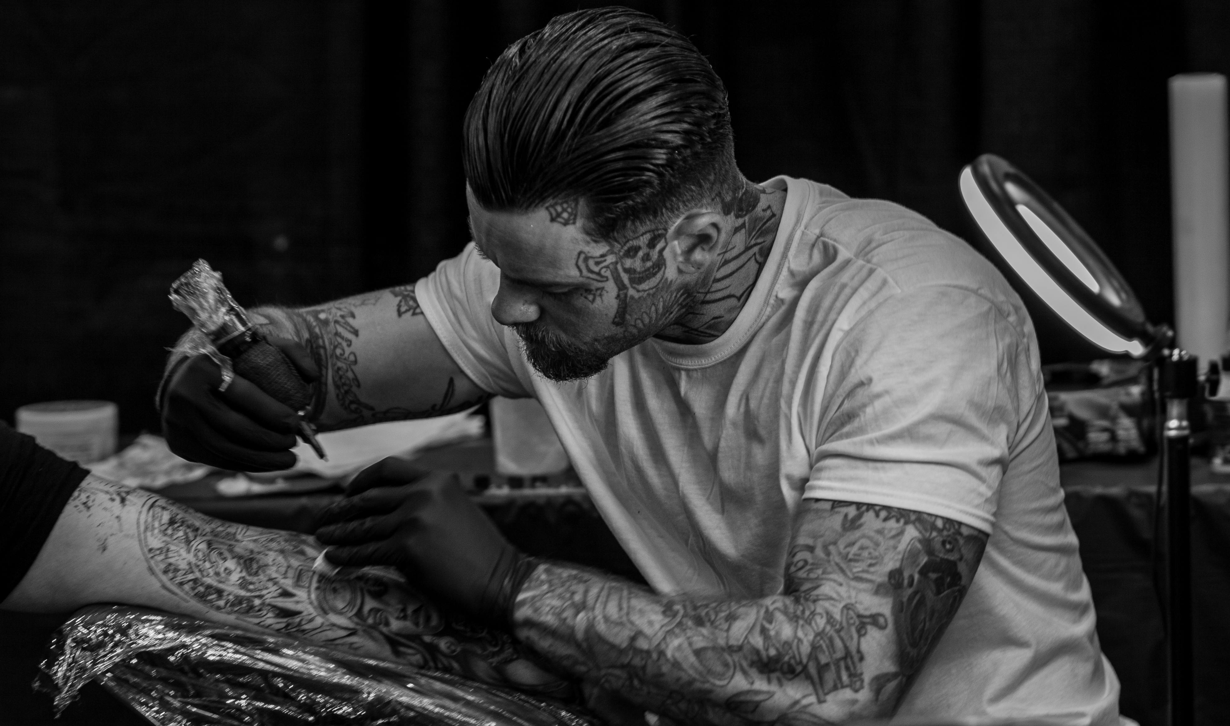 Professional tattoo artist concentrating on detailed work