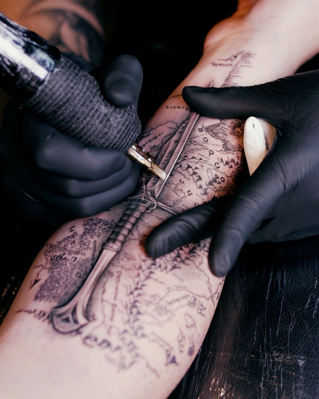 Detailed map tattoo with a sword design