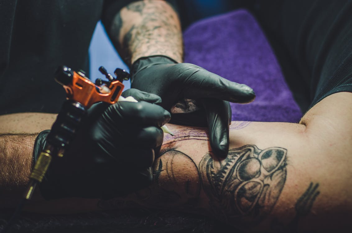 Tattoo artist working on a detailed design with professional equipment